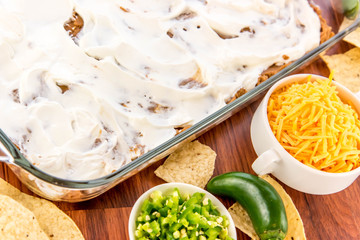 preparation of bean dip with jalapenos, sour cream and cheddar c