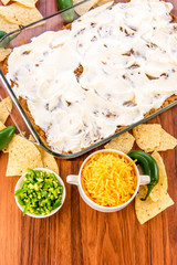 preparation of bean dip with jalapenos, sour cream and cheddar c