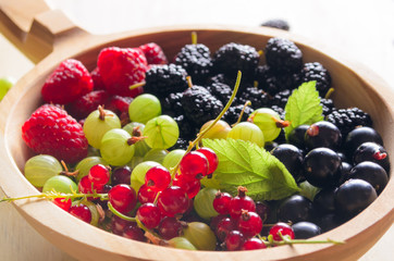 Assorted fresh garden berries on a wooden background