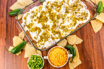 preparation of bean dip with jalapenos, sour cream and cheddar c