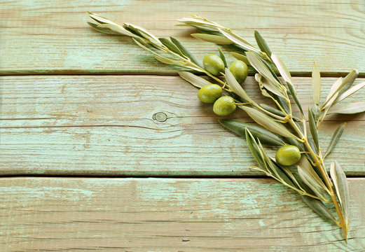 Branch of olive with olives on wooden background