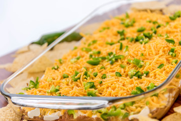 preparation of bean dip with jalapenos, sour cream and cheddar c