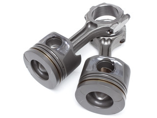 a set of pistons and rods for automobile engine on a white background
