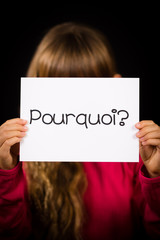 Child holding sign with French word Pourquoi - Why