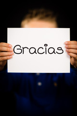 Child holding sign with Spanish word Gracias - Thank You