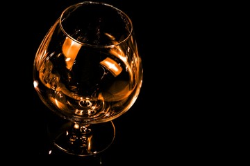 empty snifter of brandy in elegant typical cognac glass on black background