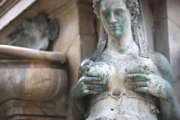 Fototapeta na wymiar Sculpture of a woman pumping milk, the Fountain of Neptune, Bologna, Italy