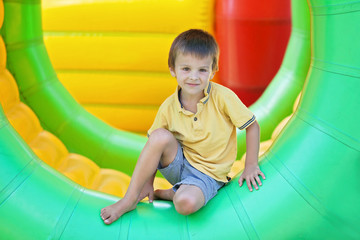 Fototapeta na wymiar Cute little boy, playing in a rolling plastic cylinder ring, ful