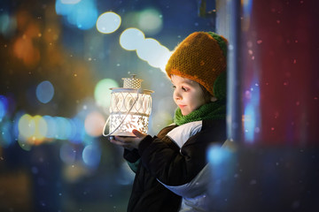 Cute boy, holding lantern outdoor © Tomsickova