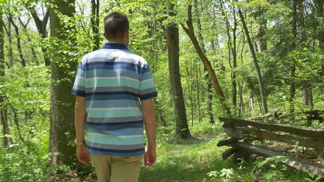4K A Man Walks Down a Path in the Forest 4371