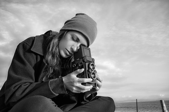 Lifestyle Portrait. Young Female Photographer Using Vintage Camera