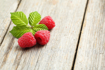 Red raspberries on grey wooden background