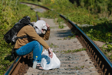 Man acting as a refugee on a railway