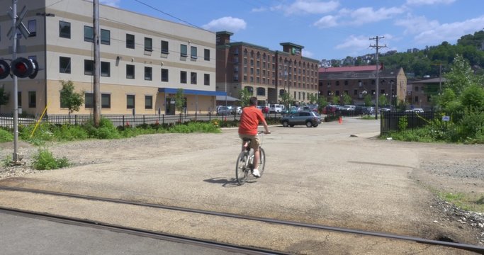4K Man on Bike Crosses Railroad Crossing
