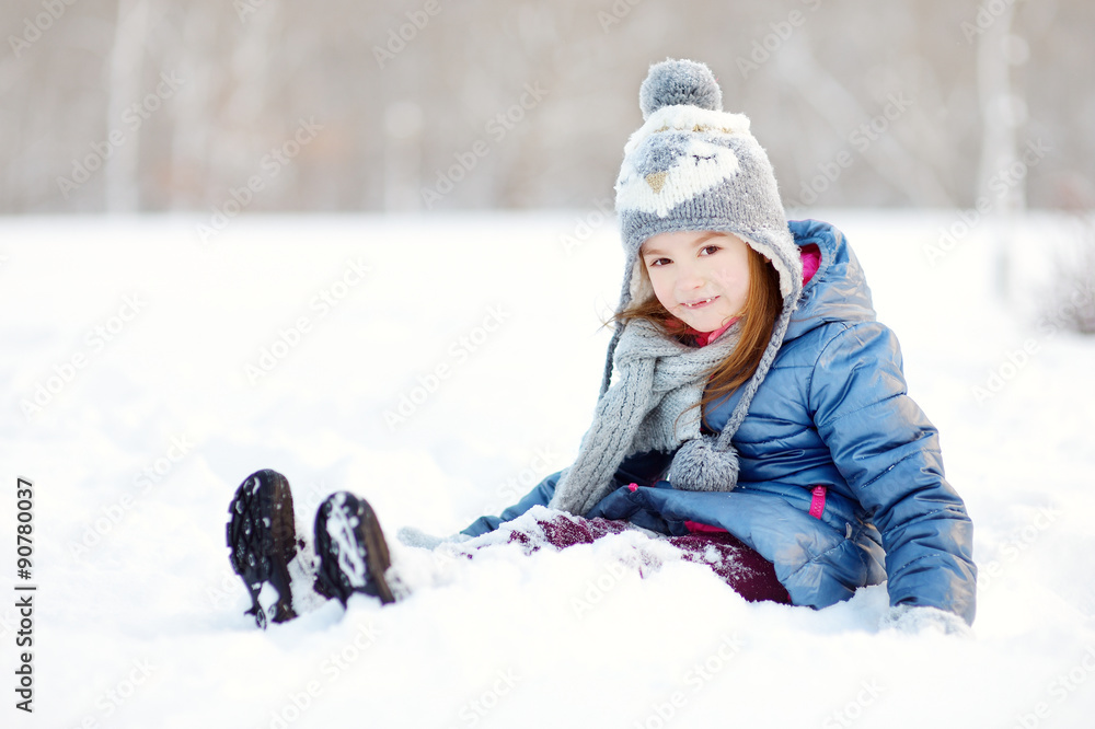 Wall mural Funny little girl having fun in winter park