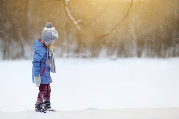 Funny little girl having fun in winter park