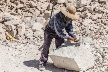 Worker in a stone quarry working on lime stone or marble