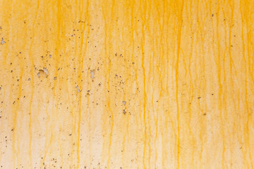 Color paint flaking and cracking texture. Rusty wall painted texture. Grange backdrop. Yellow slick on white wall