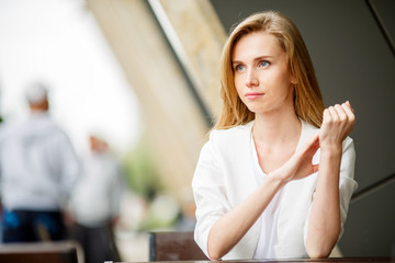 Portrait of cute blonde woman sitting in a cafe 