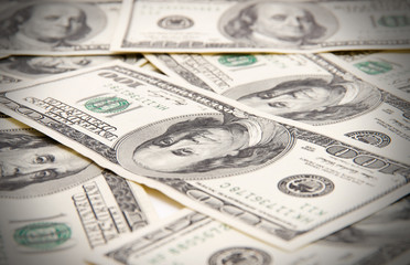 One hundred dollars pile as background.
