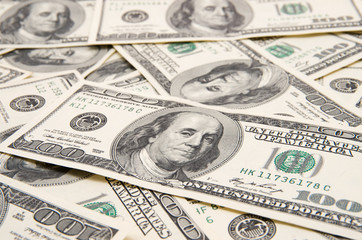 One hundred dollars pile as background.
