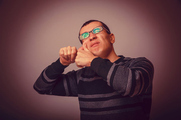 European-looking male of about thirty brunet squeezing a pimple 