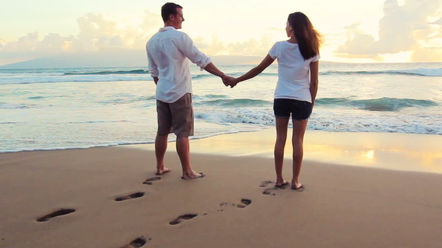 Honeymoon playful young couple. Woman jumping man lifts her up. romantic in love kissing at beach sunset. Newlywed happy young couple enjoying ocean sunset during travel holidays vacation getaway. 