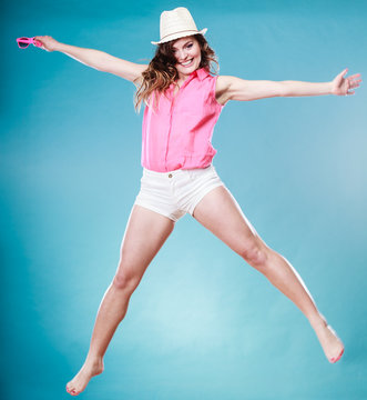 Summer woman in straw hat jumping