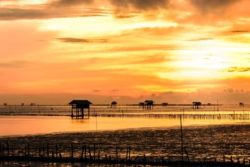 Fototapeta na wymiar Silhouette of bamboo cottage with morning sunshine in gulf of Thailand.