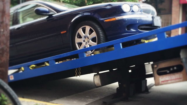Car Gets Loaded onto a Tow Truck