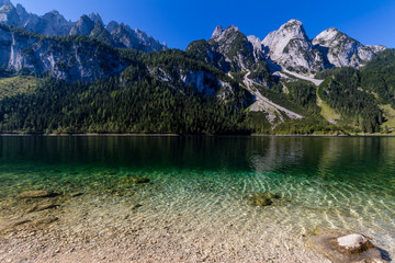 Fototapeta na wymiar Beautiful landscape of alpine lake with crystal clear green water and mountains in background, Gosausee, Austria