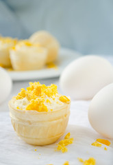 tartlet with cottage cheese, garlic and eggs on blue background