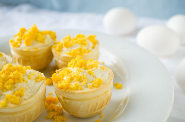 tartlet with cottage cheese, garlic and eggs on blue background