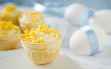tartlet with cottage cheese, garlic and eggs on blue background
