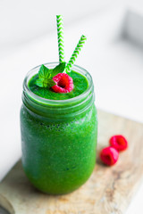 Fresh green smoothie on white wooden background