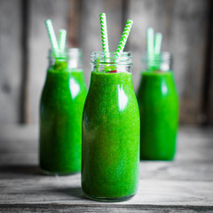 Fresh green smoothie on rustic wooden background