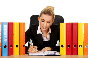 Smile businesswoman with binders by a desk