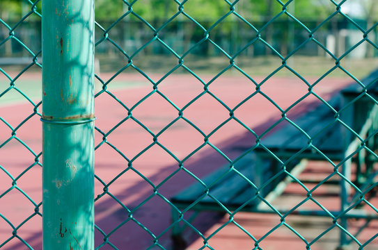 Wire Net Beside Outdoor Sports Court and Mini Stadium In Blurred Background.