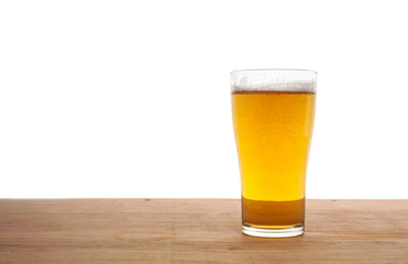 Glass of beer on wooden bar isolated