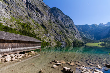 Beautiful landscape of alpine lake with crystal clear green water and mountains in background, Obersee, Germany