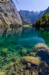 Fototapeta na wymiar Beautiful landscape of alpine lake with crystal clear green water and mountains in background, Obersee, Germany