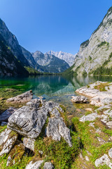 Beautiful landscape of alpine lake with crystal clear green water and mountains in background, Obersee, Germany
