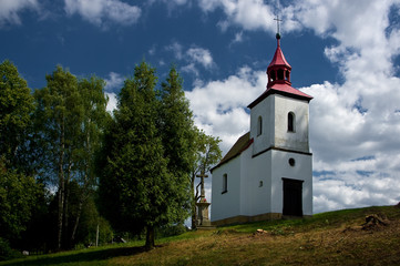 Fototapeta na wymiar A small Catholic church standing in the landscape.