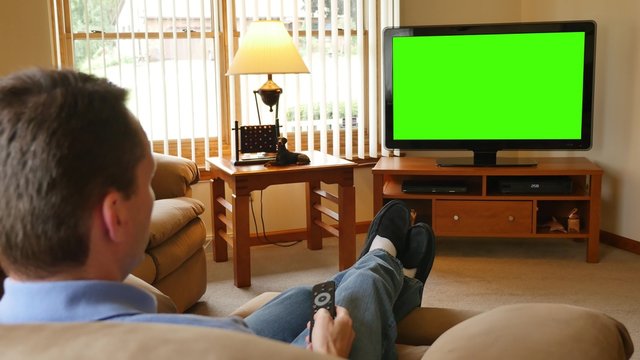 4K Man at Home Watches Television and Channel Surfs