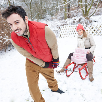 Paar beim Schlittenfahren zu Weihnachten