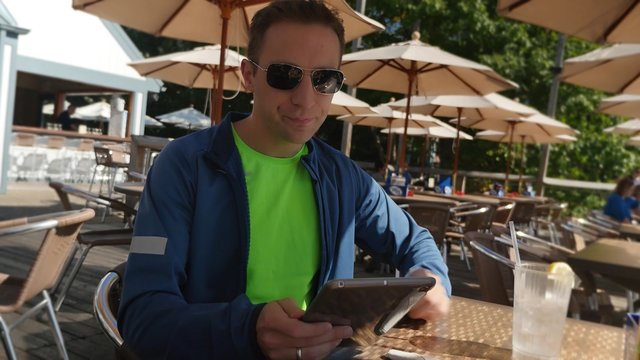 4K Man at Cafe Uses an iPad Tablet PC