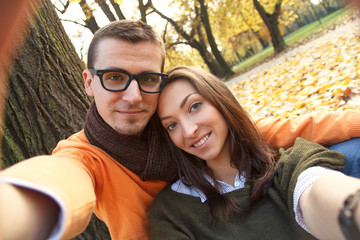 Young couple taking selfie in park