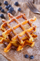 Belgian waffles with blueberries sprinkled with powdered sugar, closeup. selective focus