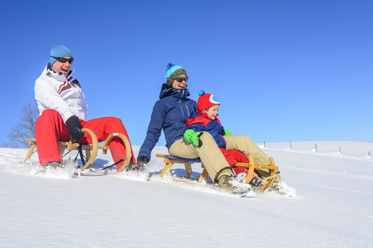 fröhliche Rodler im Pulverschnee