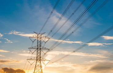 High voltage transmission lines on orange and blue sky, sunrise